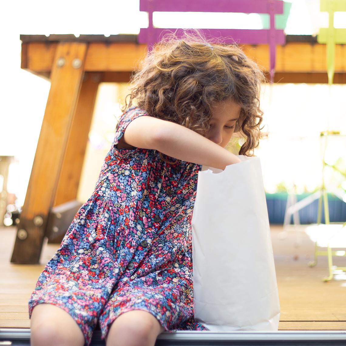 Una niña al lado de las bolsas
