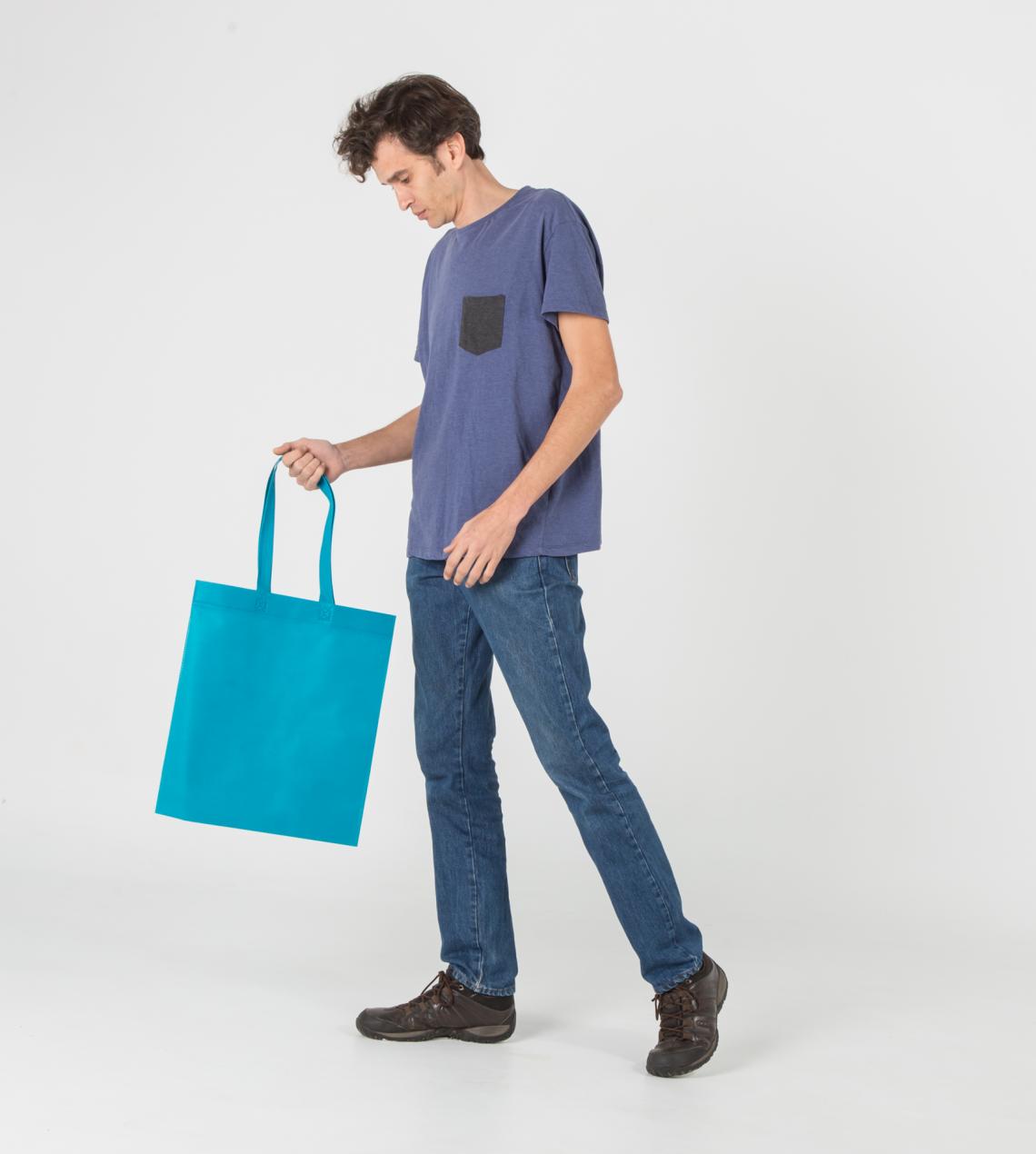 Bolsas de tela reciclada de tamaño mediano con asas largas sujetadas por un hombre