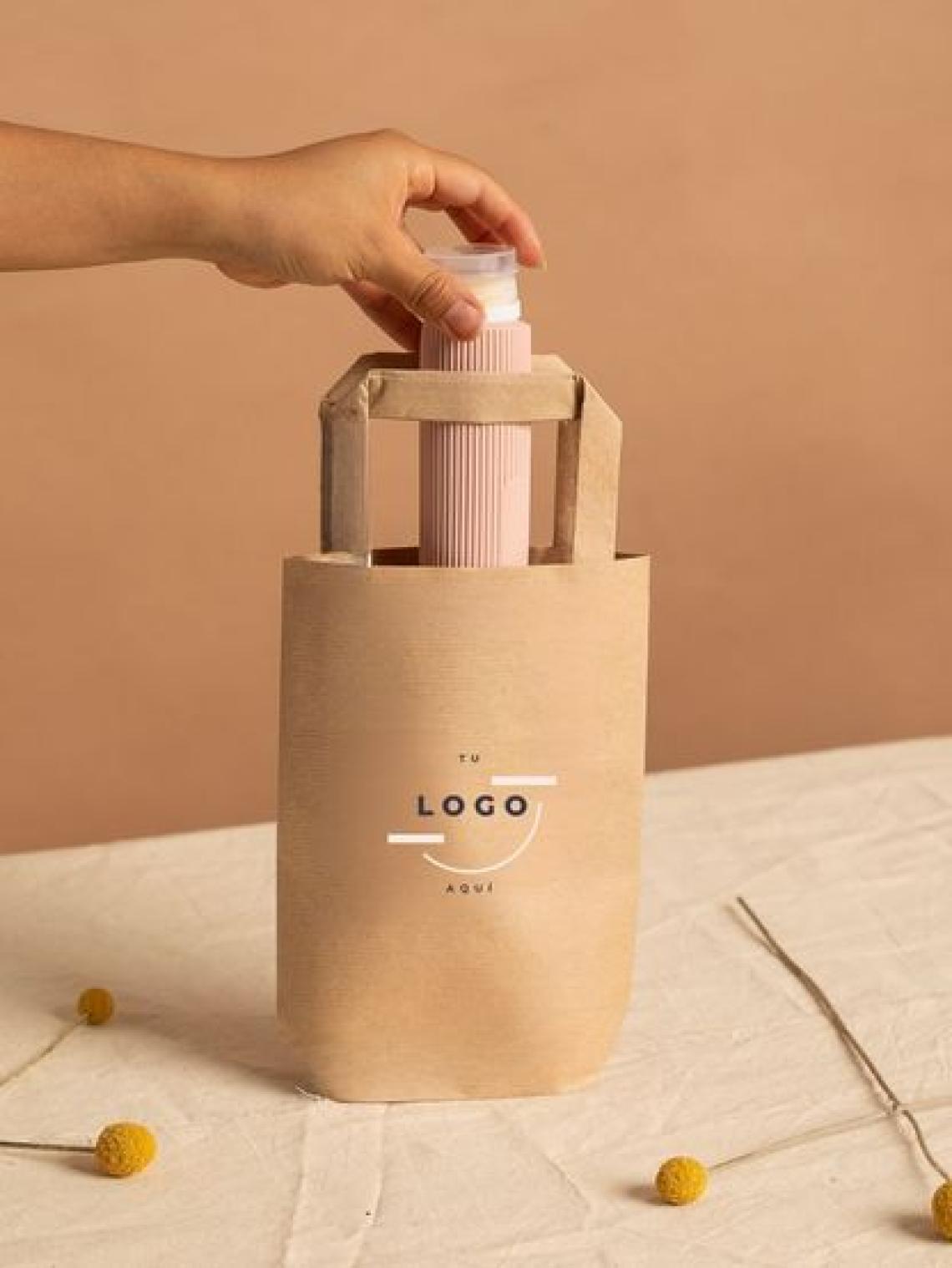 Bolsa de papel kraft hexagonal pequeña con asas planas reforzadas, tamaño 21x6x10 cm, fabricada en España con impacto social y opción de personalización con logo para packaging ecológico.