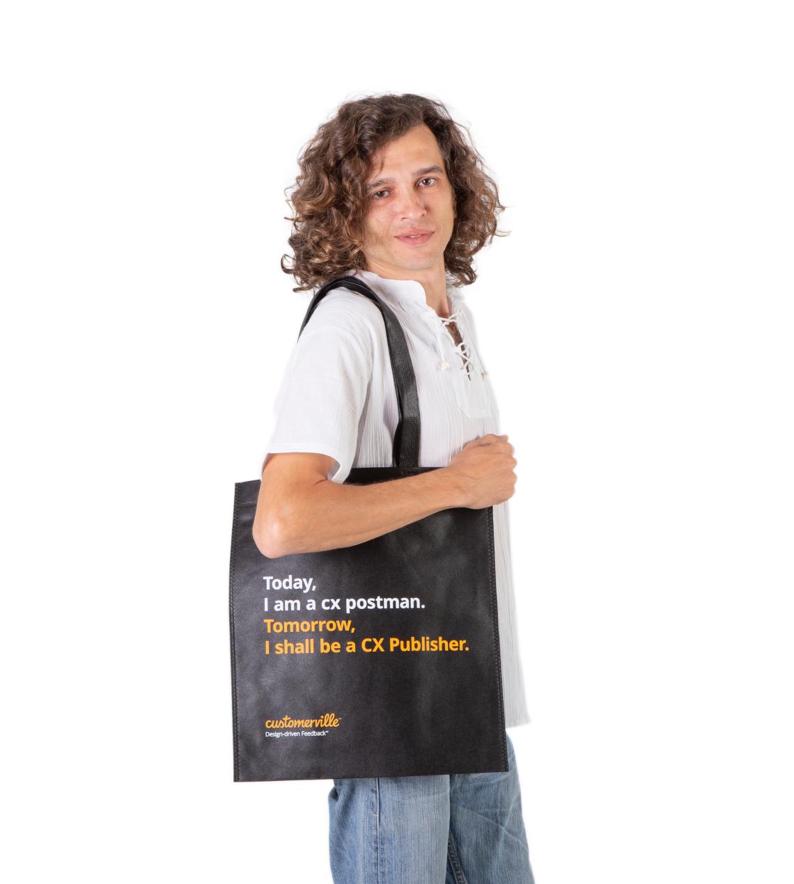 Bolsas medianas de tela reciclada de color negro sujetadas por un hombre