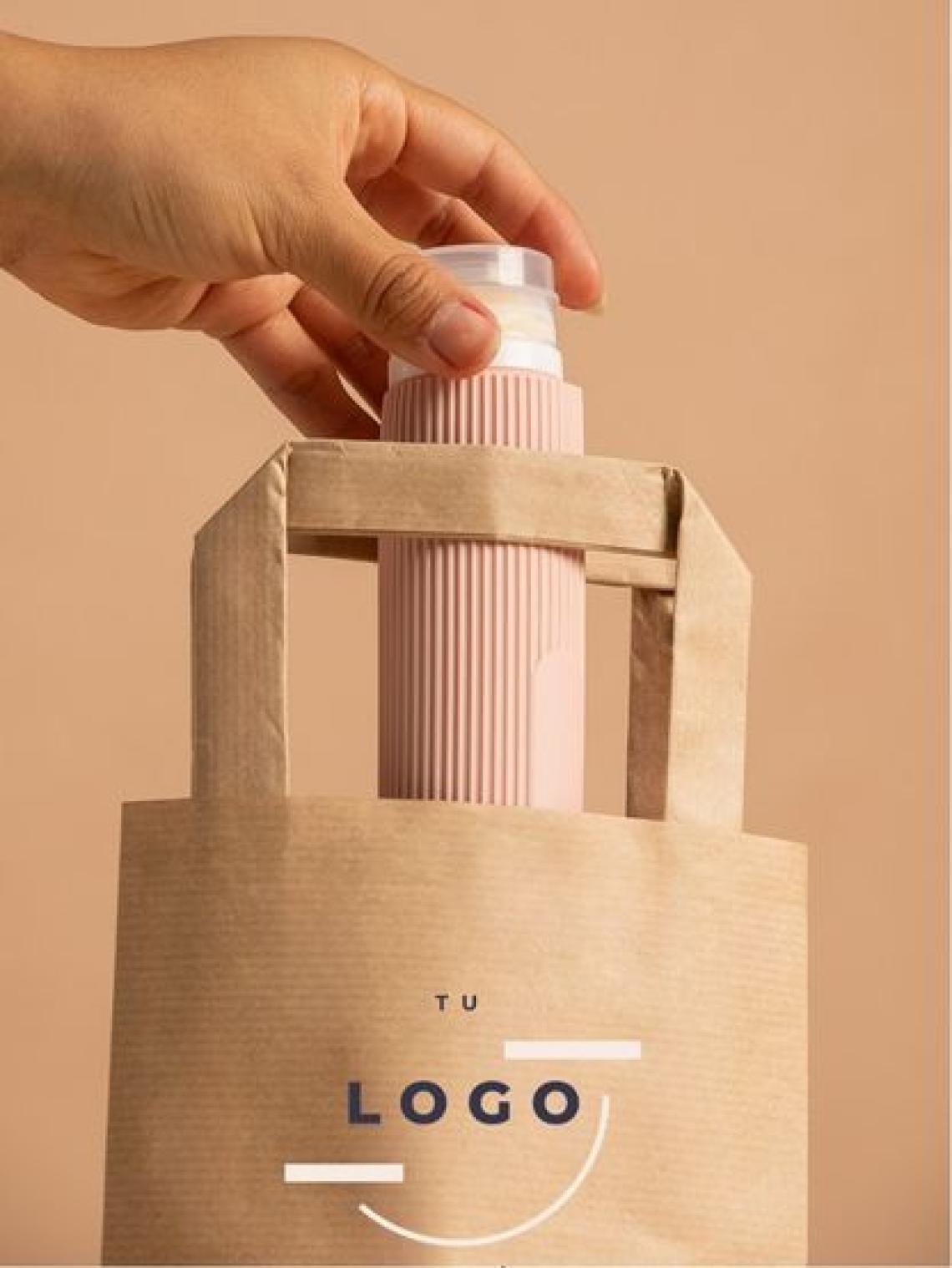 Bolsa de papel kraft hexagonal pequeña con asas planas reforzadas, tamaño 21x6x10 cm, fabricada en España con impacto social y opción de personalización con logo, ideal para packaging ecológico.