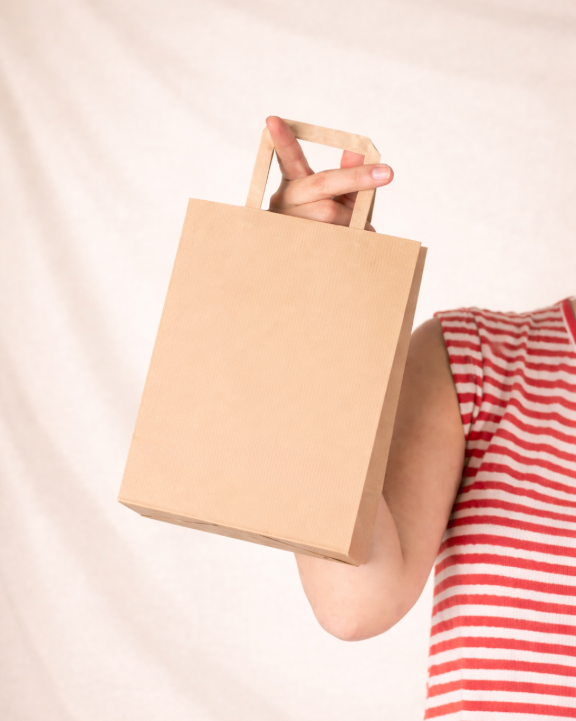 Una mujer sujetando las bolsas de papel de asa plana