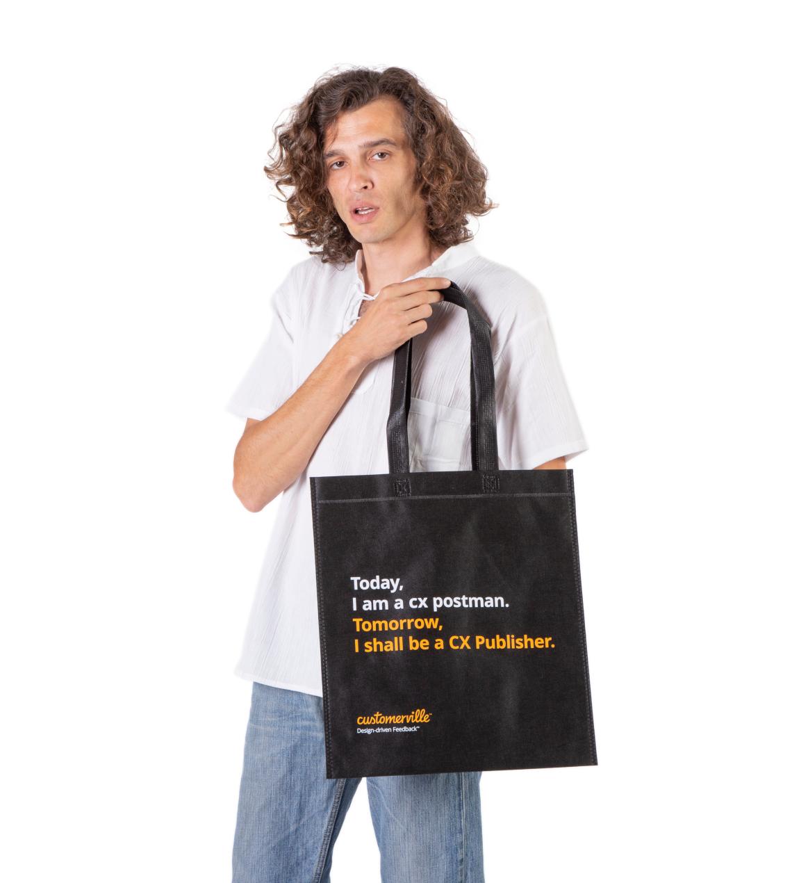 Bolsas medianas de tela reciclada de color negro sujetadas por un hombre