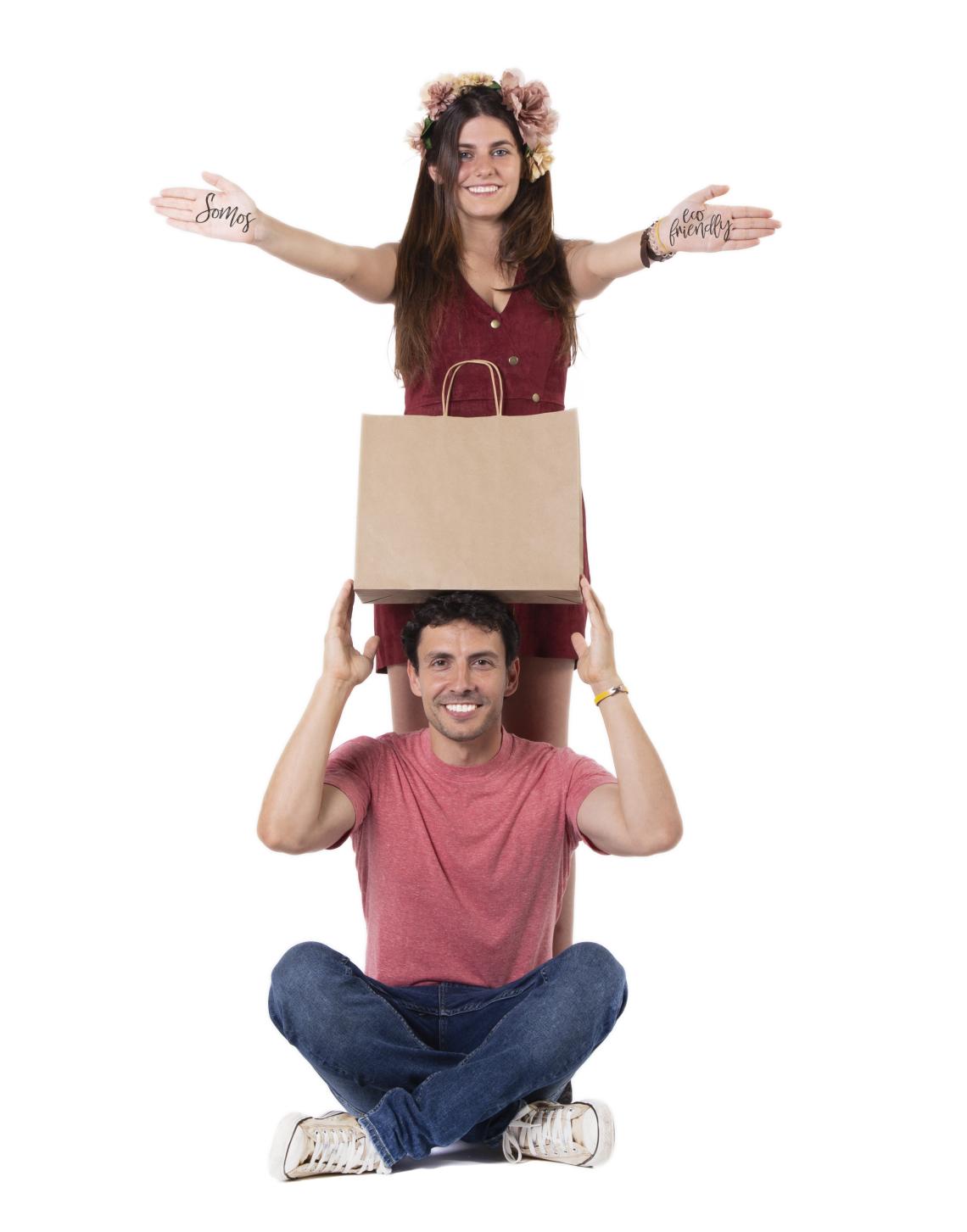 Bolsas de papel kraft medianas al lado de un hombre y una mujer