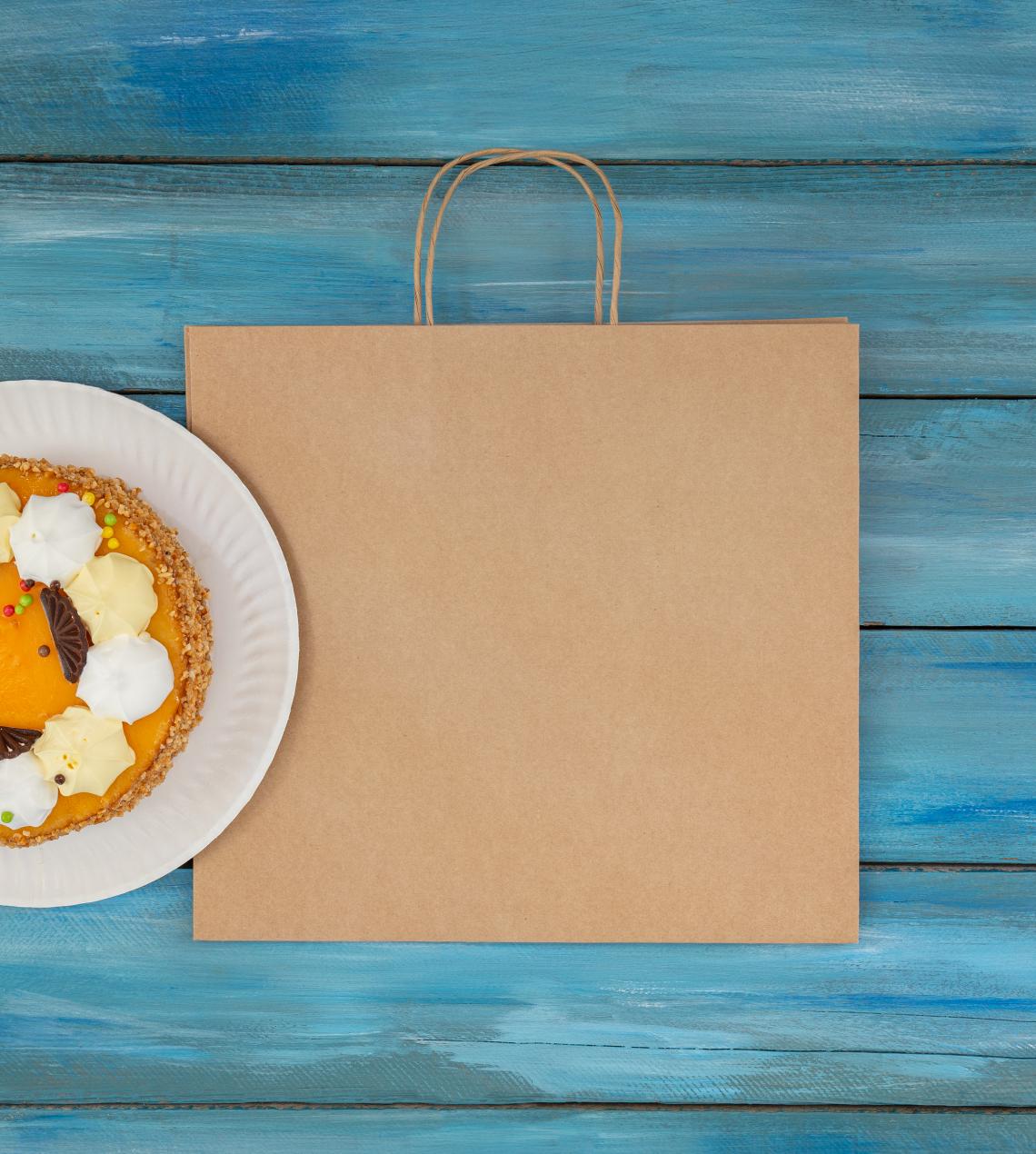 Bolsas de papel kraft con base ancha con una tarta al lado