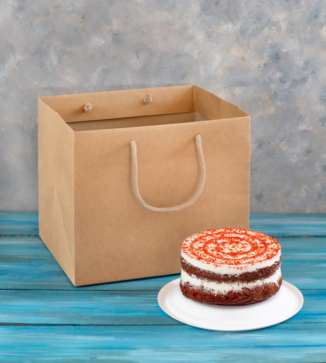 Bolsas de papel kraft con base ancha junto a un pastel