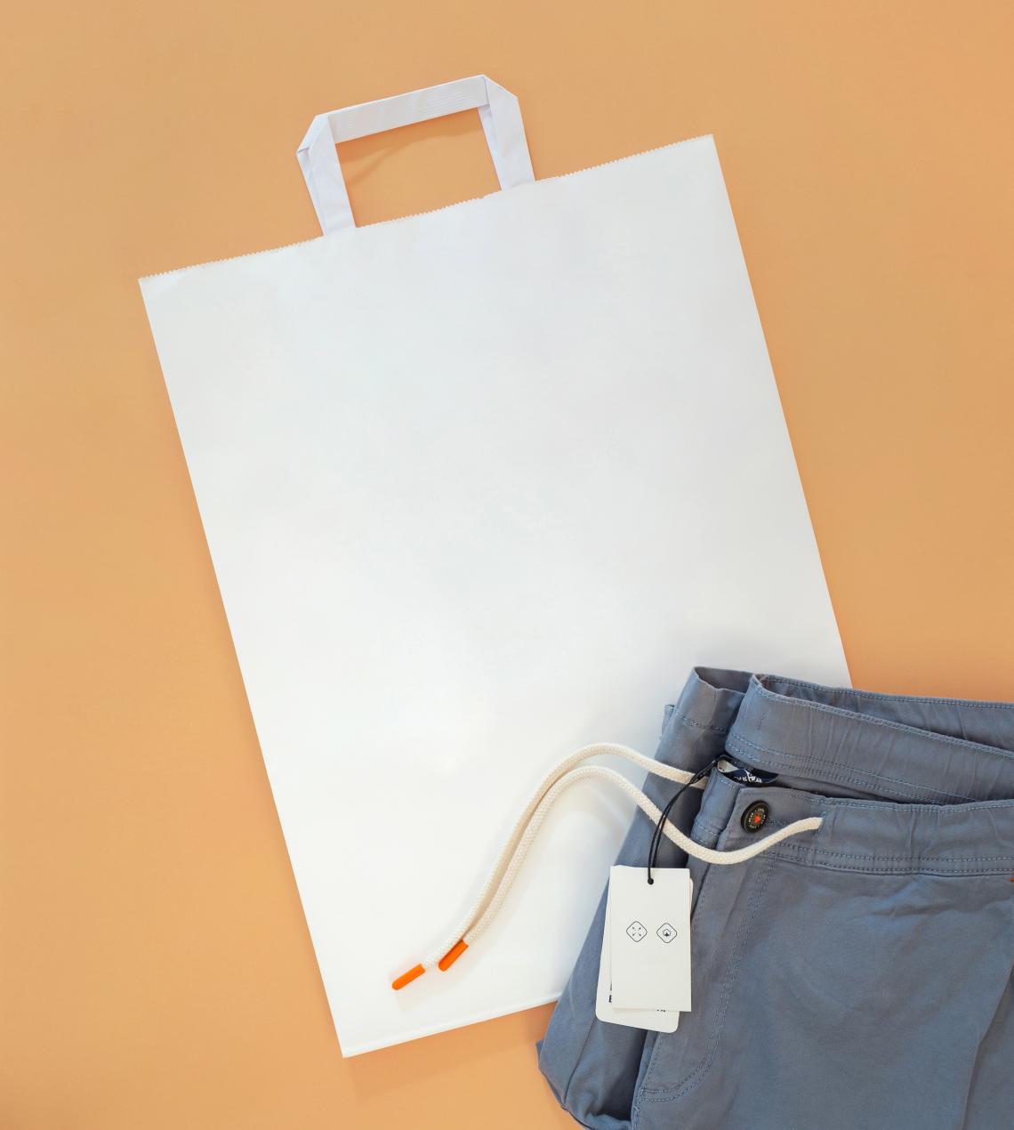 Bolsas de papel de asas planas junto a unas chaquetas