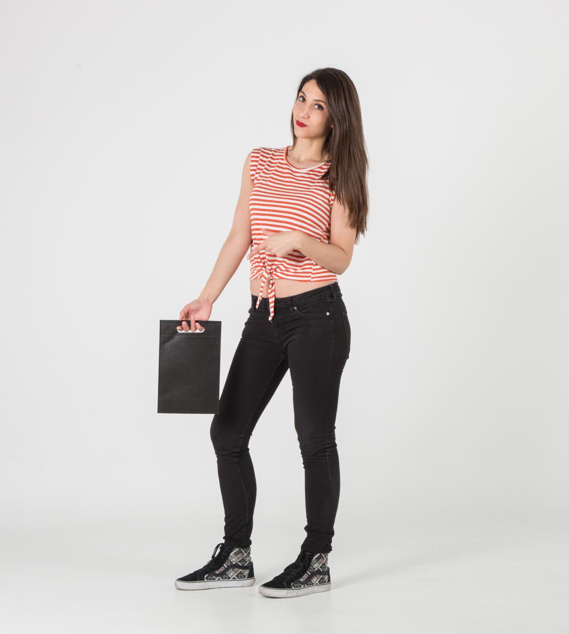 Bolsas negras con asas troqueladas sujetadas por una mujer