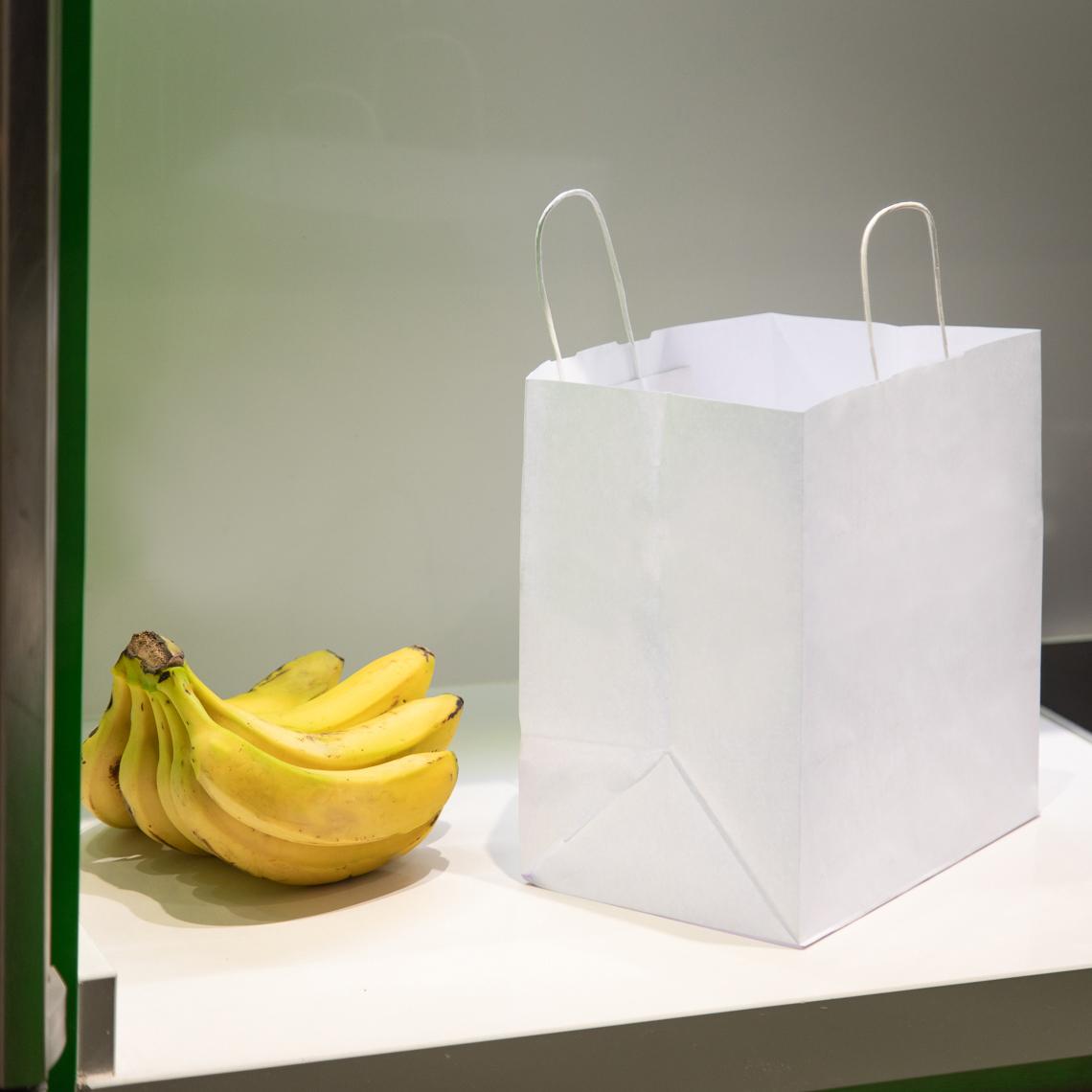 Bolsas de comida para llevar al lado de unos plátanos