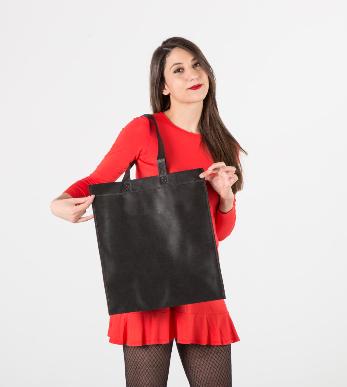 Bolsas medianas de tela reciclada de color negro sujetadas por una mujer