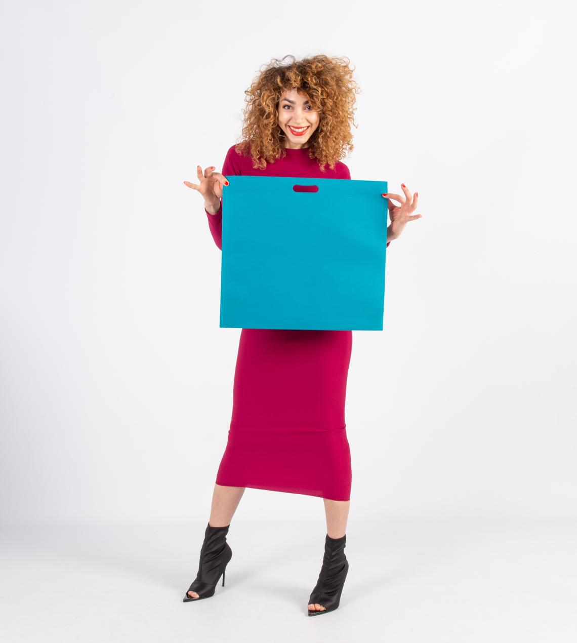 Bolsas con asas troqueladas grandes sujetadas por una mujer