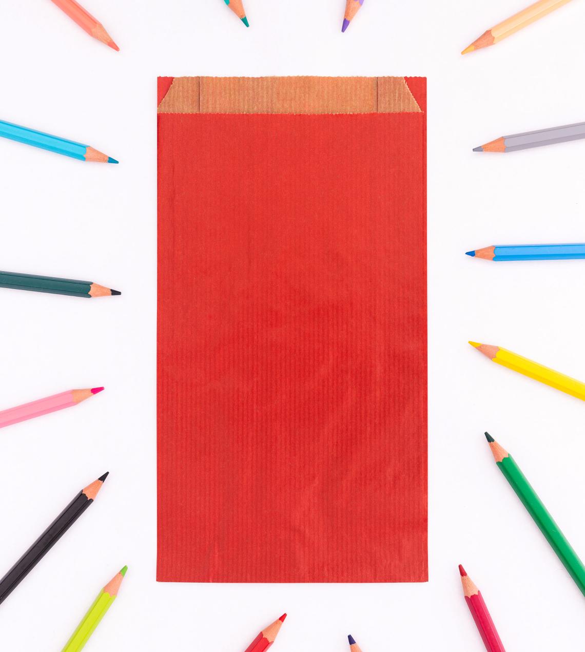 Sobres de papel kraft con fuelle lateral de color rojo con lápices de colores alrededor