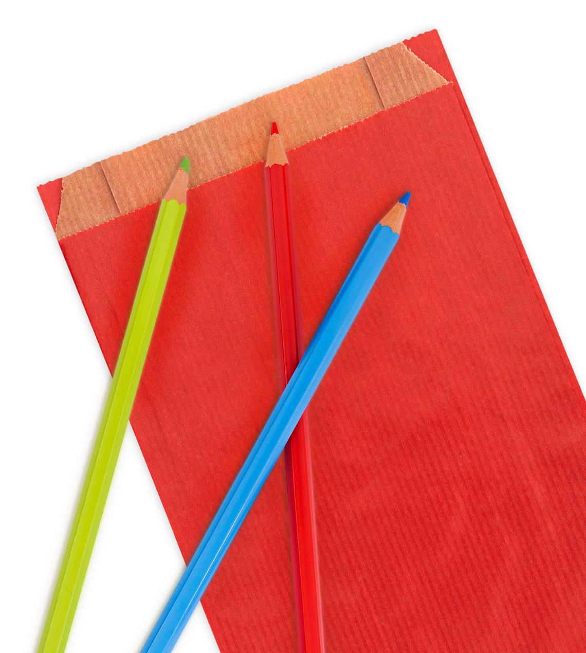 Sobres de papel kraft con fuelle lateral de color rojo con lápices de colores alrededor