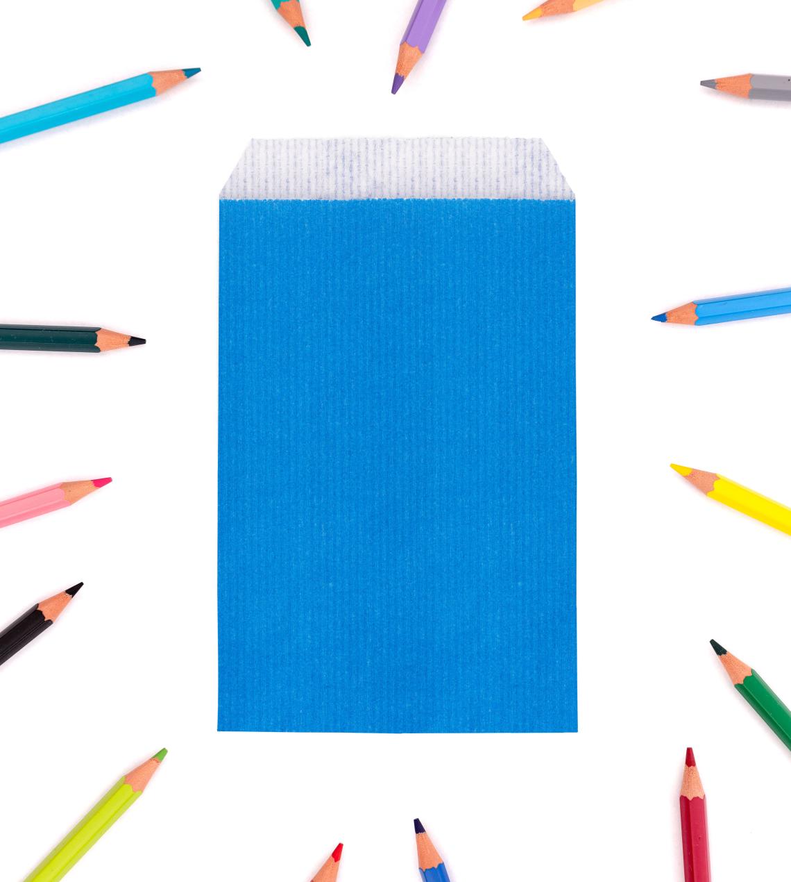 Sobres de papel pequeños con lápices de colores alrededor