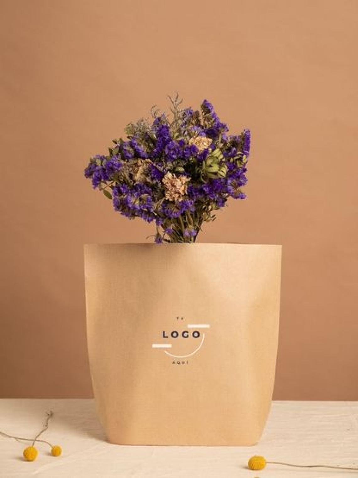 Un ramo de flores dentro de una bolsa de papel kraft con opción a poner el logo de la marca