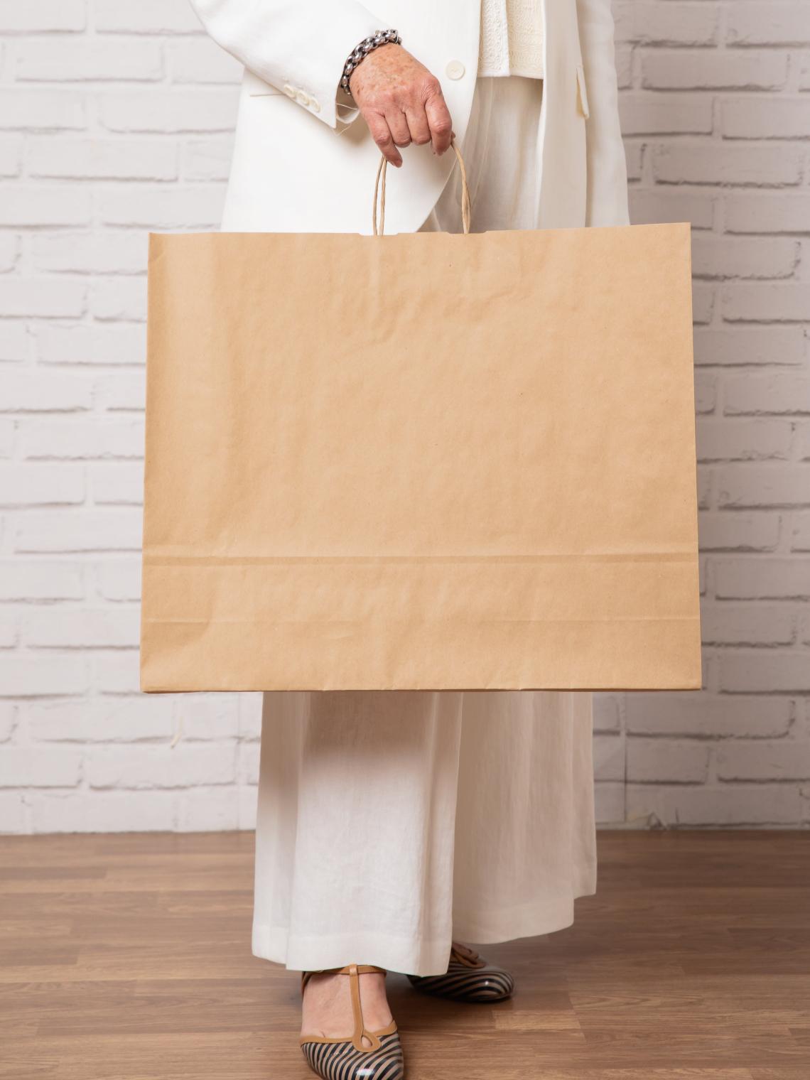 Bolsas de papel kraft grandes junto a una mujer