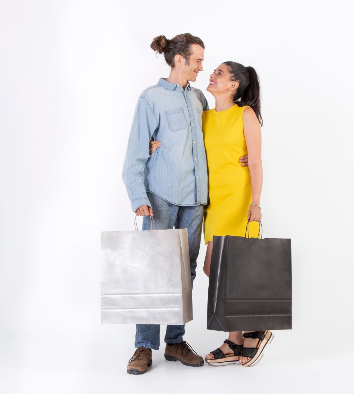 Bolsas de papel grandes de color granate junto a una pareja