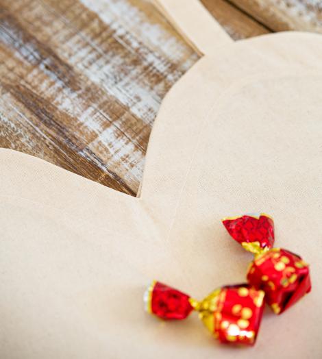 Bolsas de algodón orgánico en forma de corazón con caramelos alrededor