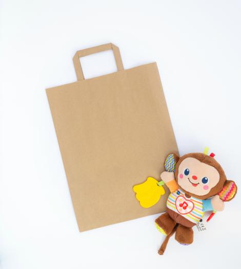 Bolsas de papel medianas de asas planas junto a un juguete