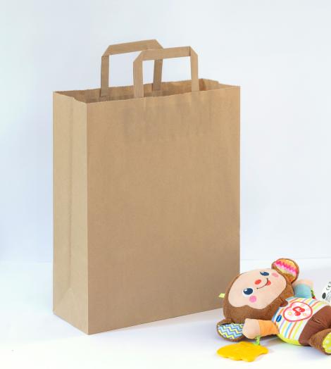 Bolsas de papel medianas de asas planas junto a un juguete