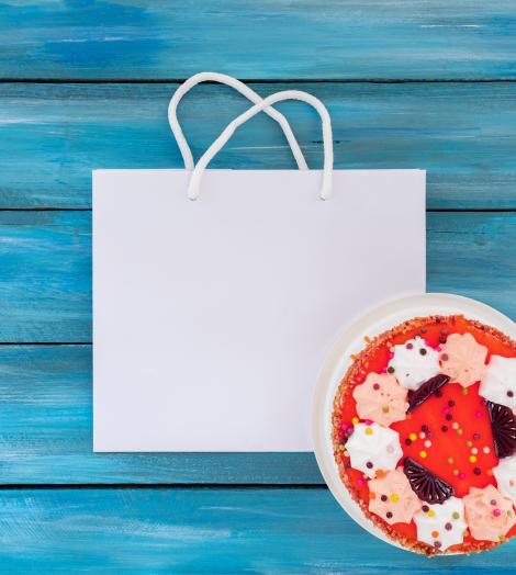 Comprar bolsas de papel hechas a medida para pastelerías Bolsas de papel blancas junto a una tarta