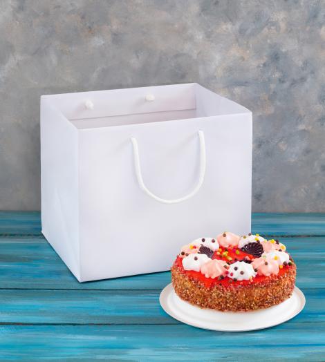 Comprar bolsas de papel hechas a mano para pastelerías Bolsas de papel blancas junto a una tarta