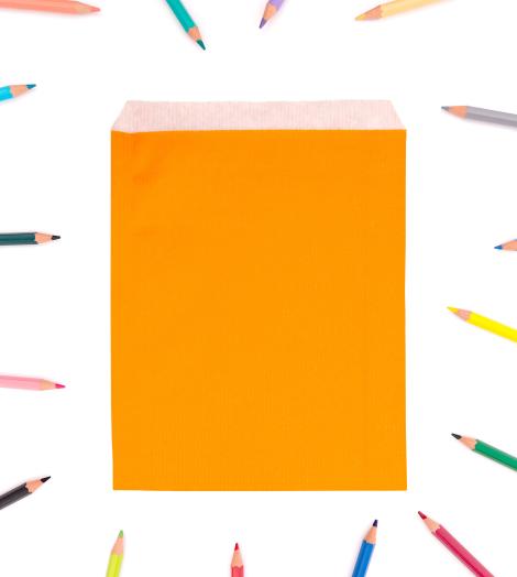 Sobres de color naranja de papel con lápices de colores alrededor