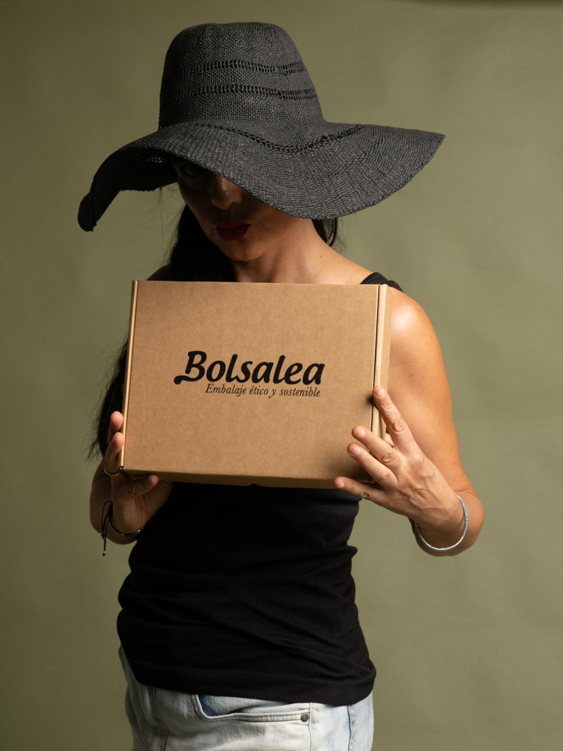 Una persona sujetando la caja de cartón reciclado 27x20x5