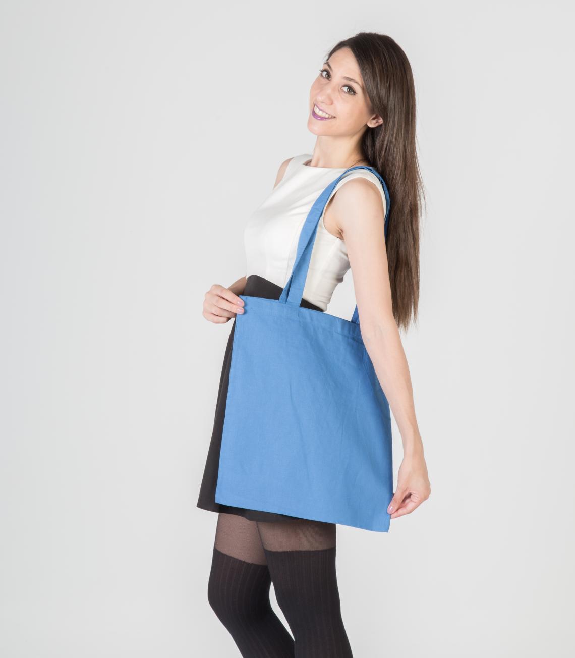 Bolsas de algodón de color azul marndo mostradas por una mujer