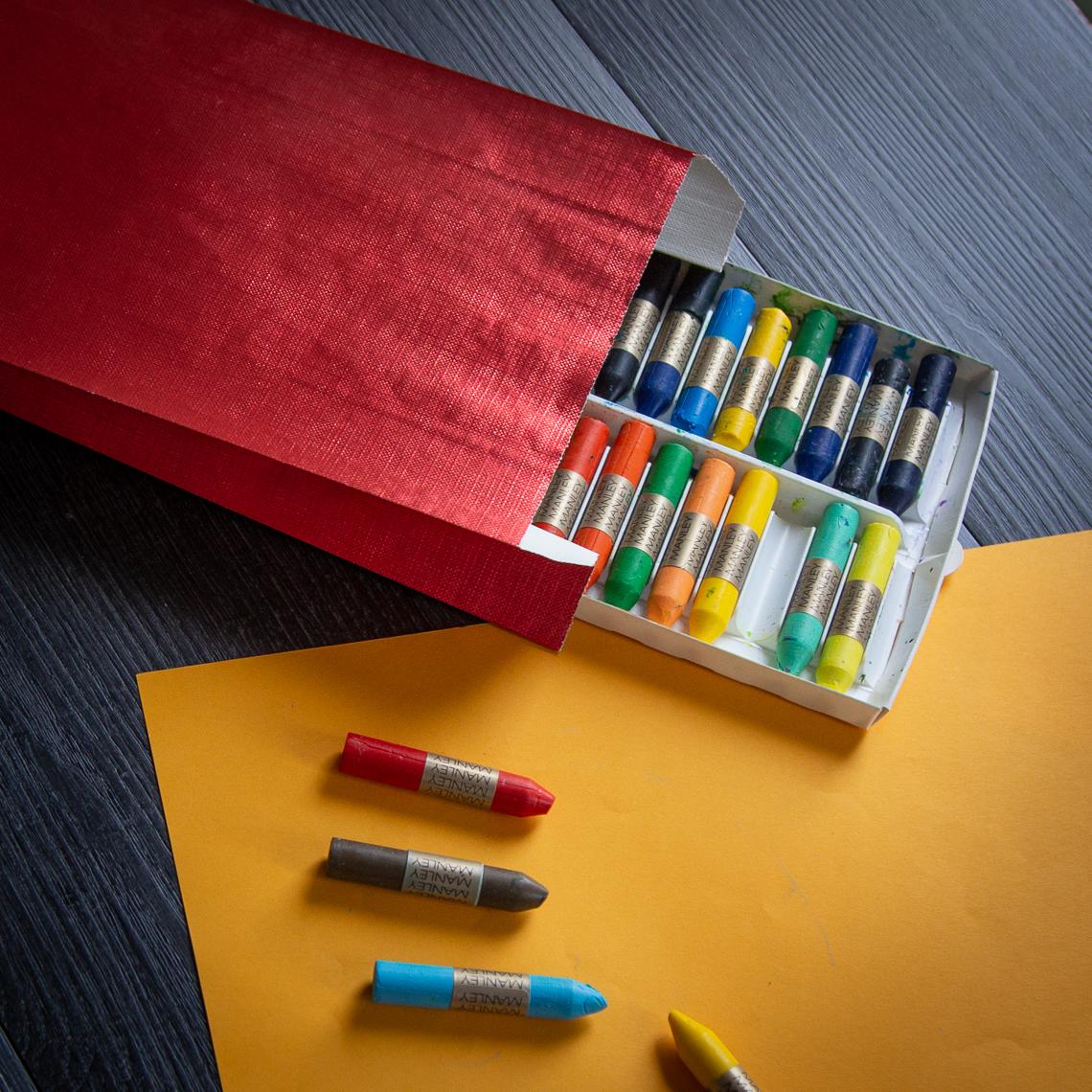 Sobres de papel metalizados rojos con pinturas alrededor
