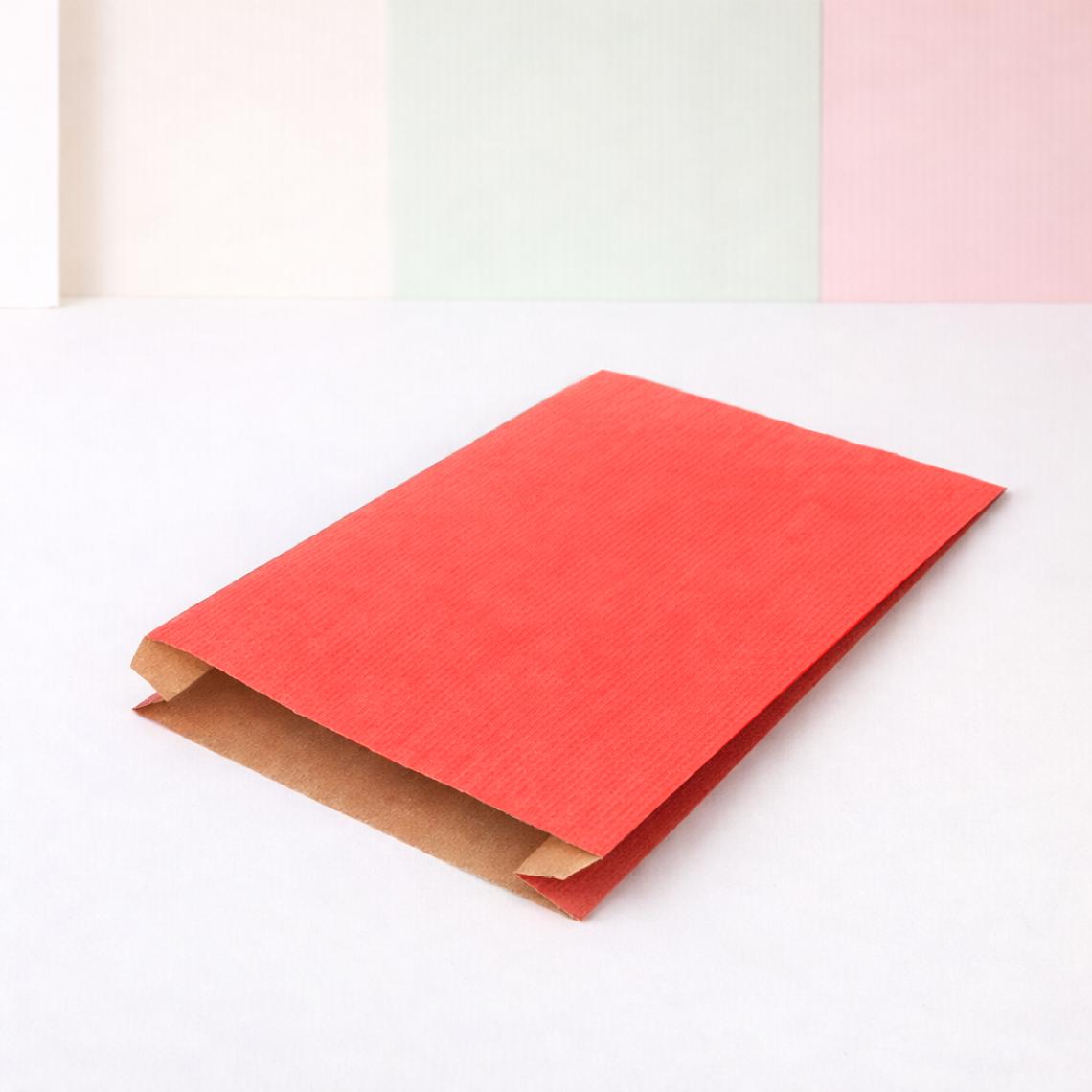 Sobres de papel rojos con lápices de colores alrededor
