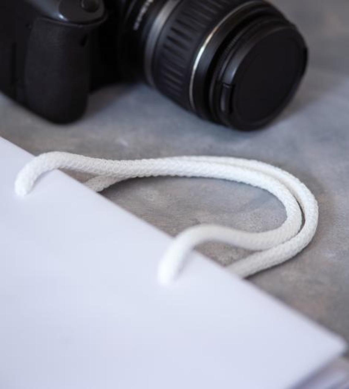 Bolsas de papel blancas con base ancha junto a una cámara