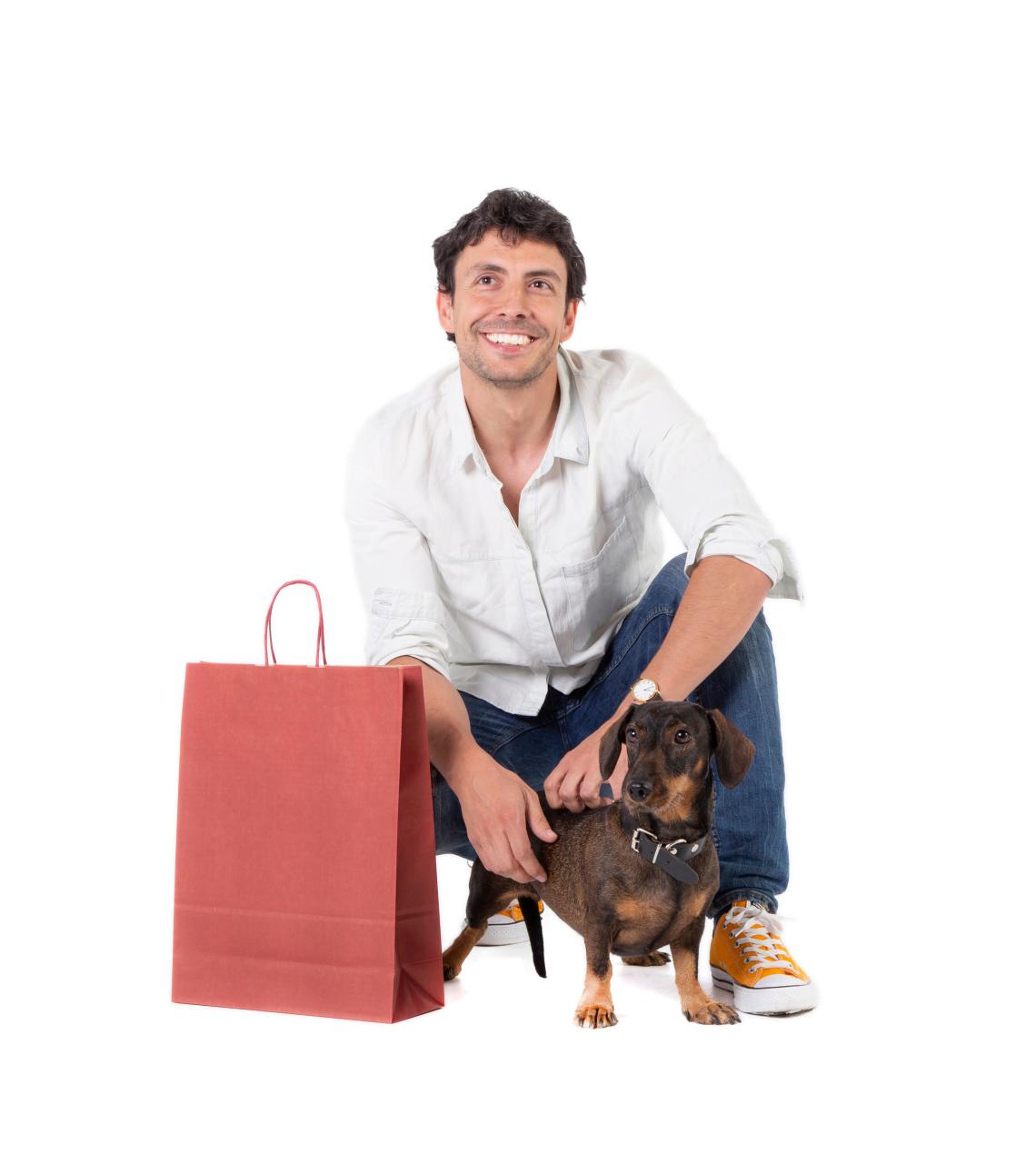 Bolsas de papel granate junto a un hombre y un perrito