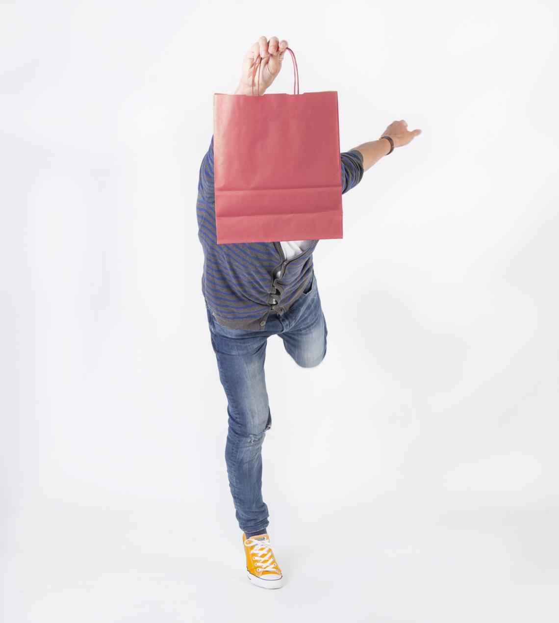 Bolsas de papel granate mostradas por un hombre
