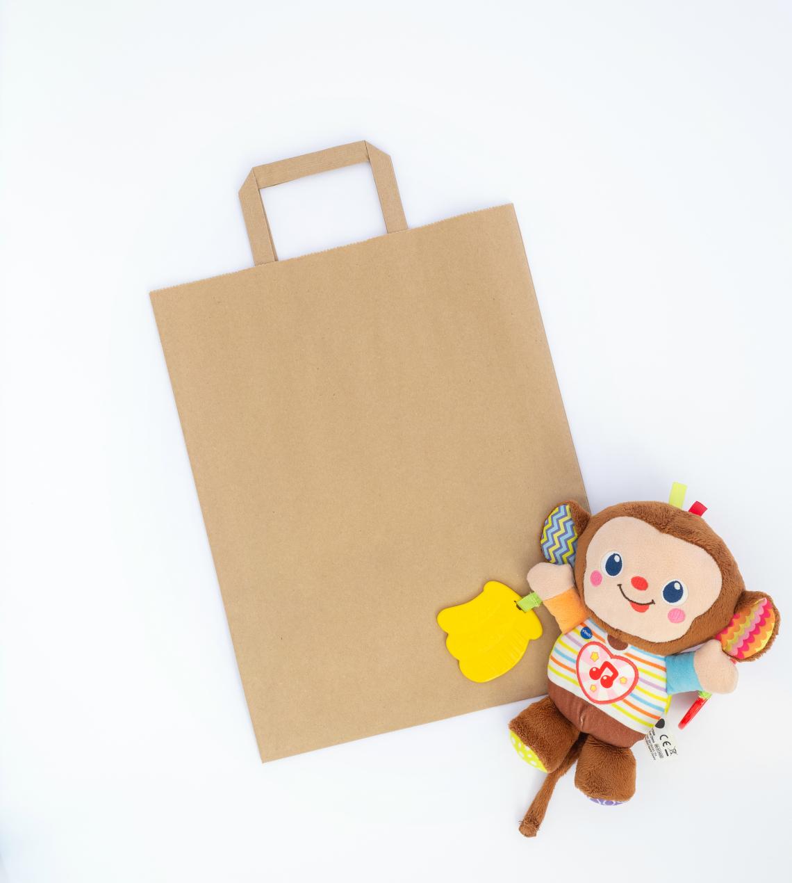 Bolsas de papel medianas de asas planas junto a un juguete