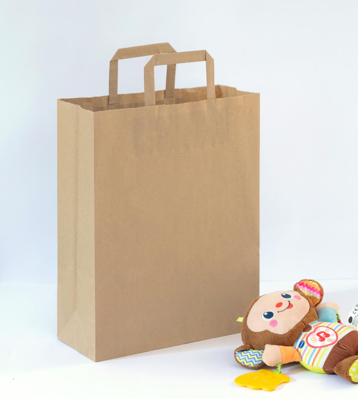Bolsas de papel medianas de asas planas junto a un juguete