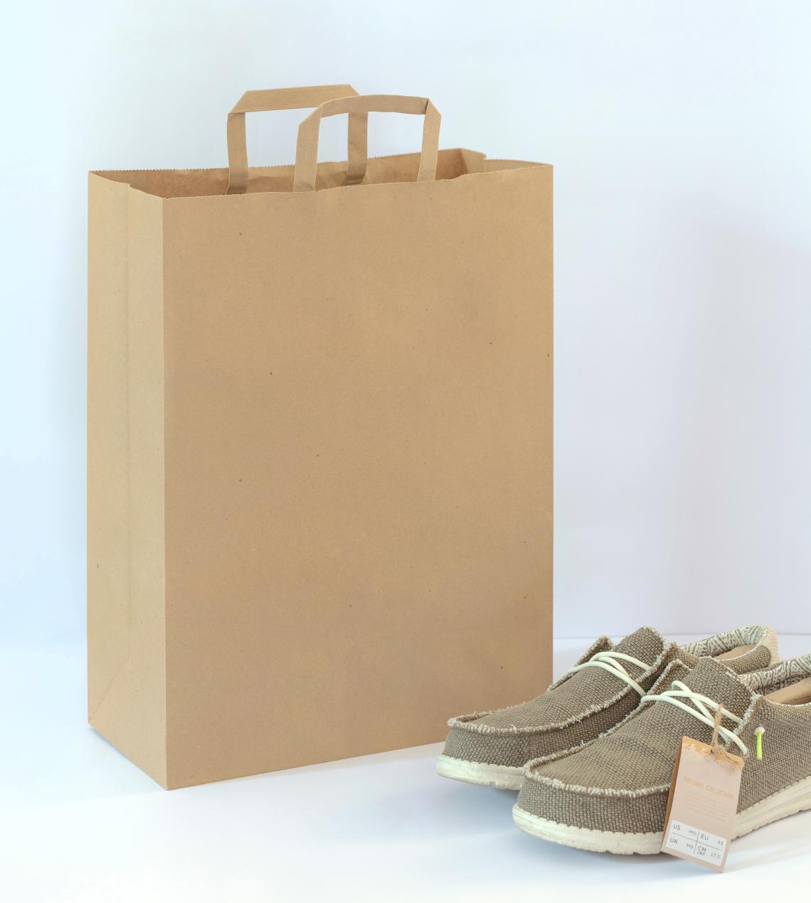 Bolsas de papel con asas planas junto a unos zapatos
