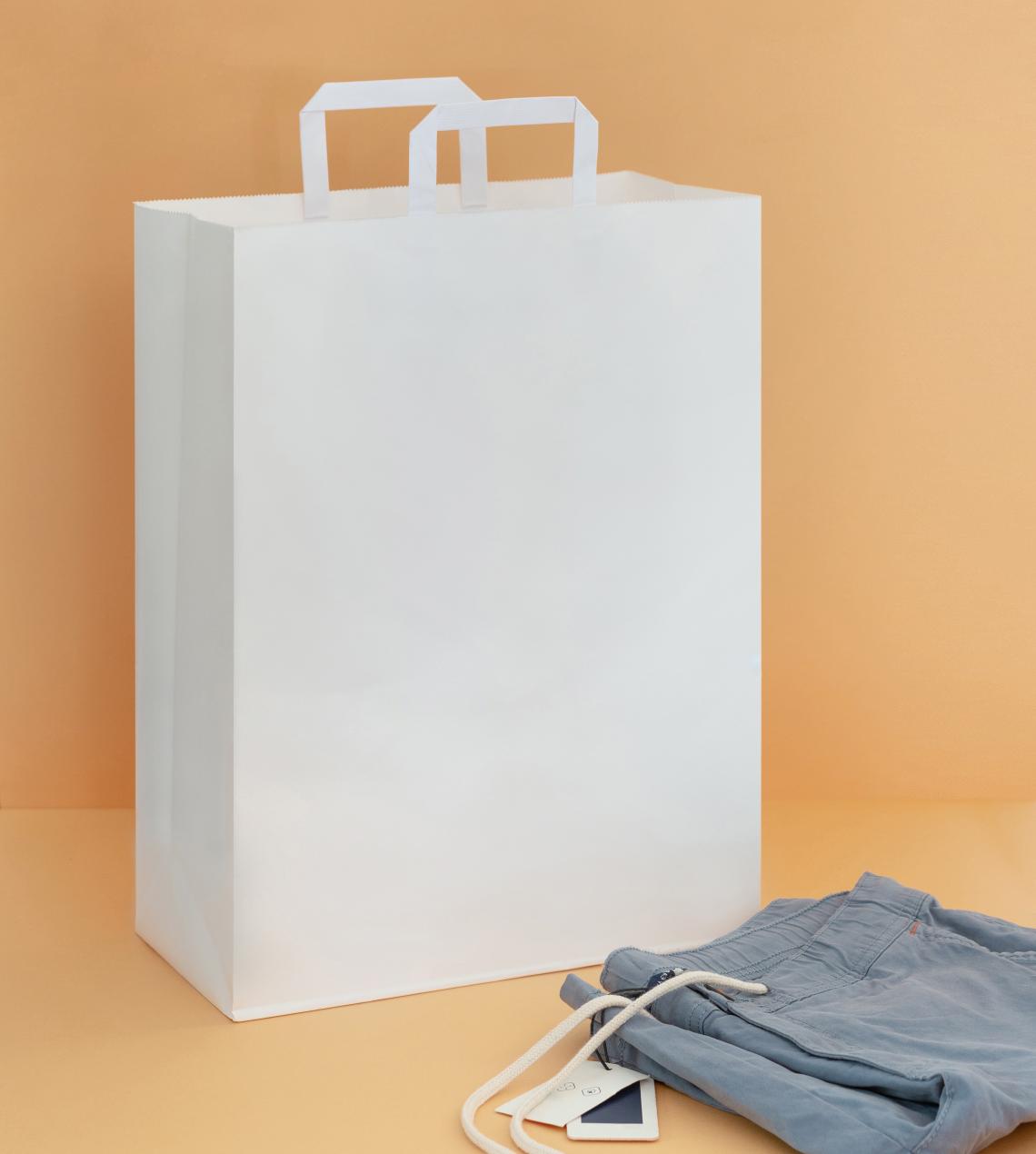 Bolsas de papel de asas planas junto a unas chaquetas