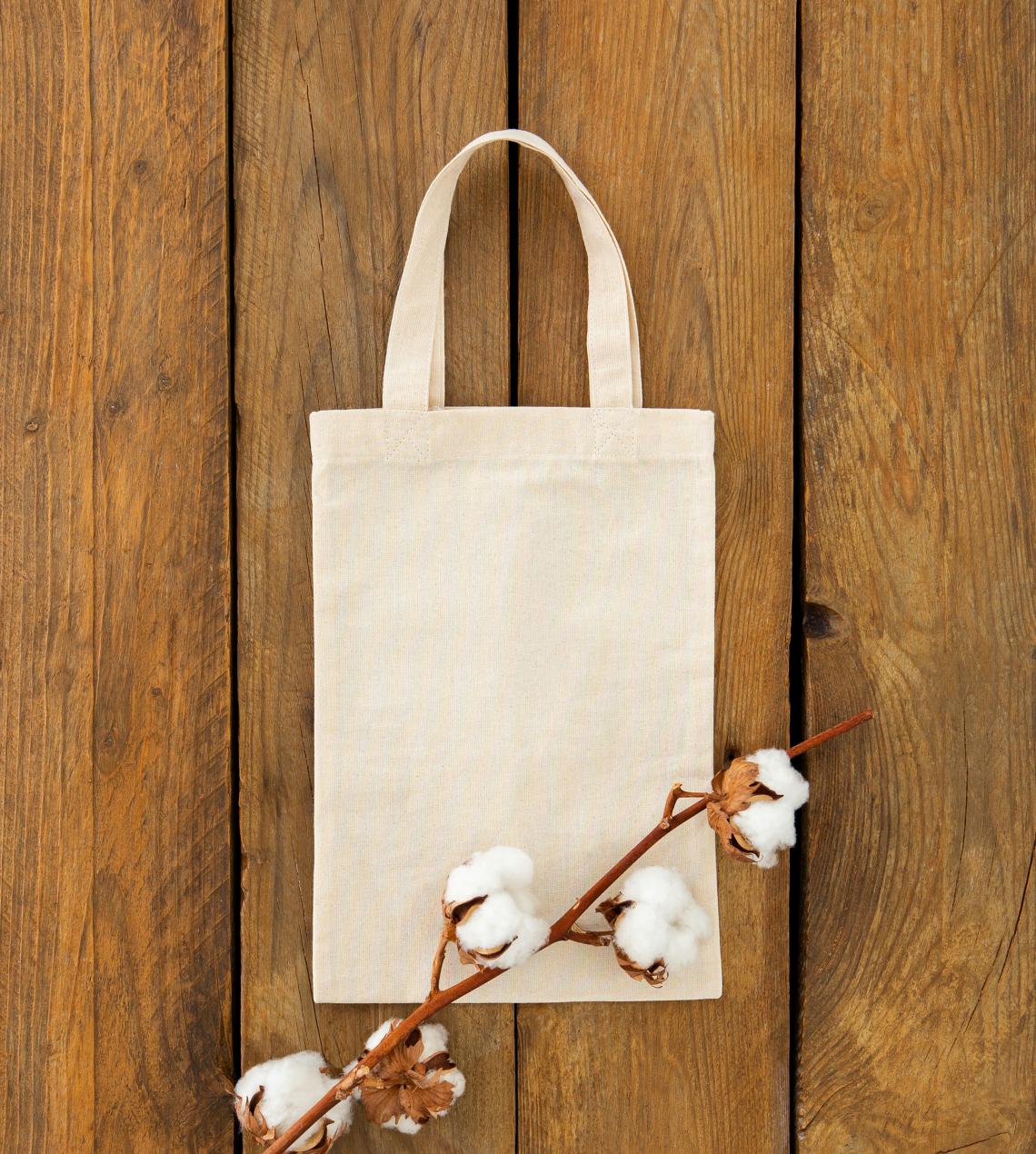 Bolsas de algodón orgánico junto a una rama de algodón