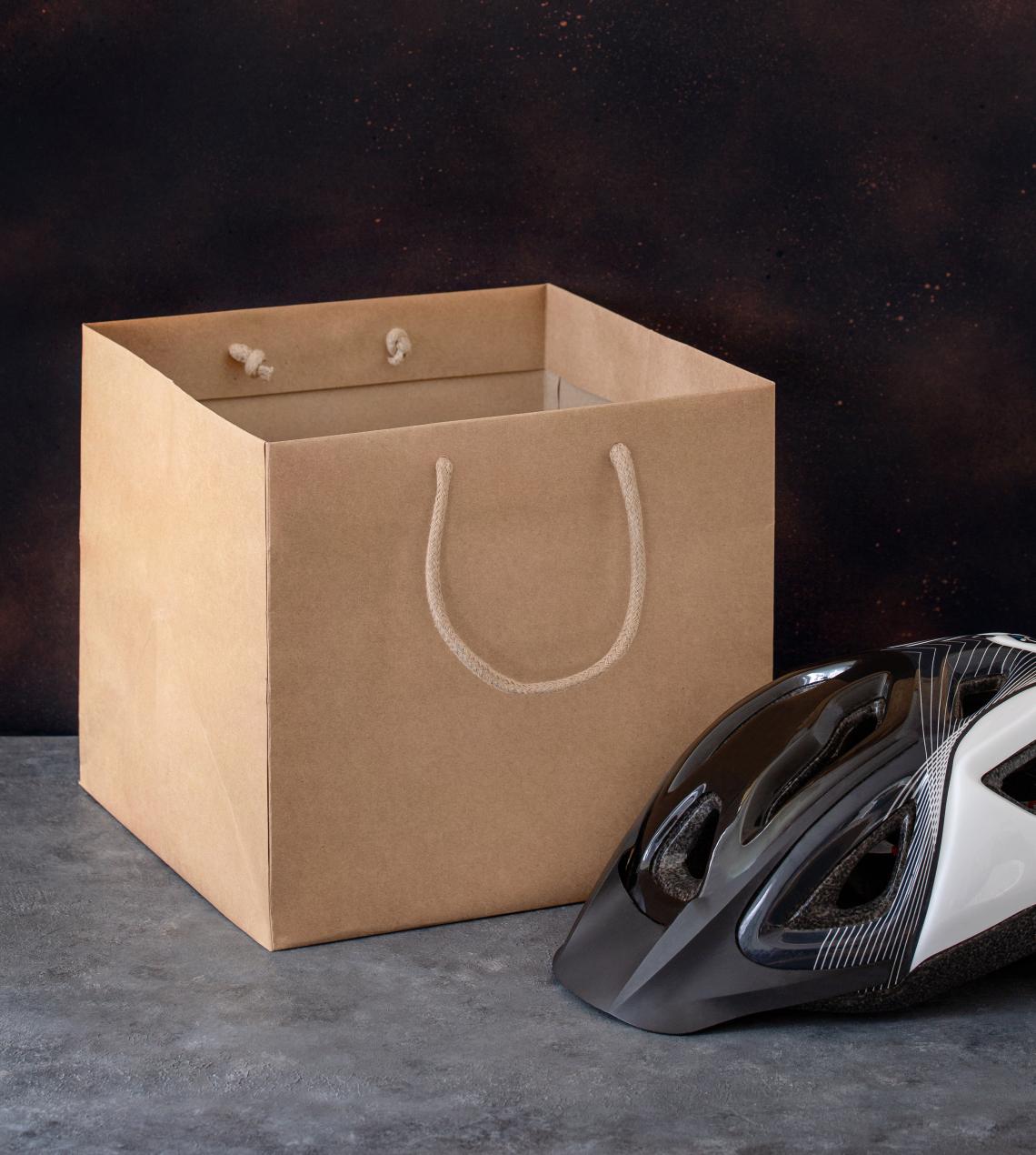 Bolsas de papel blancas con base ancha junto a un casco de bicicleta