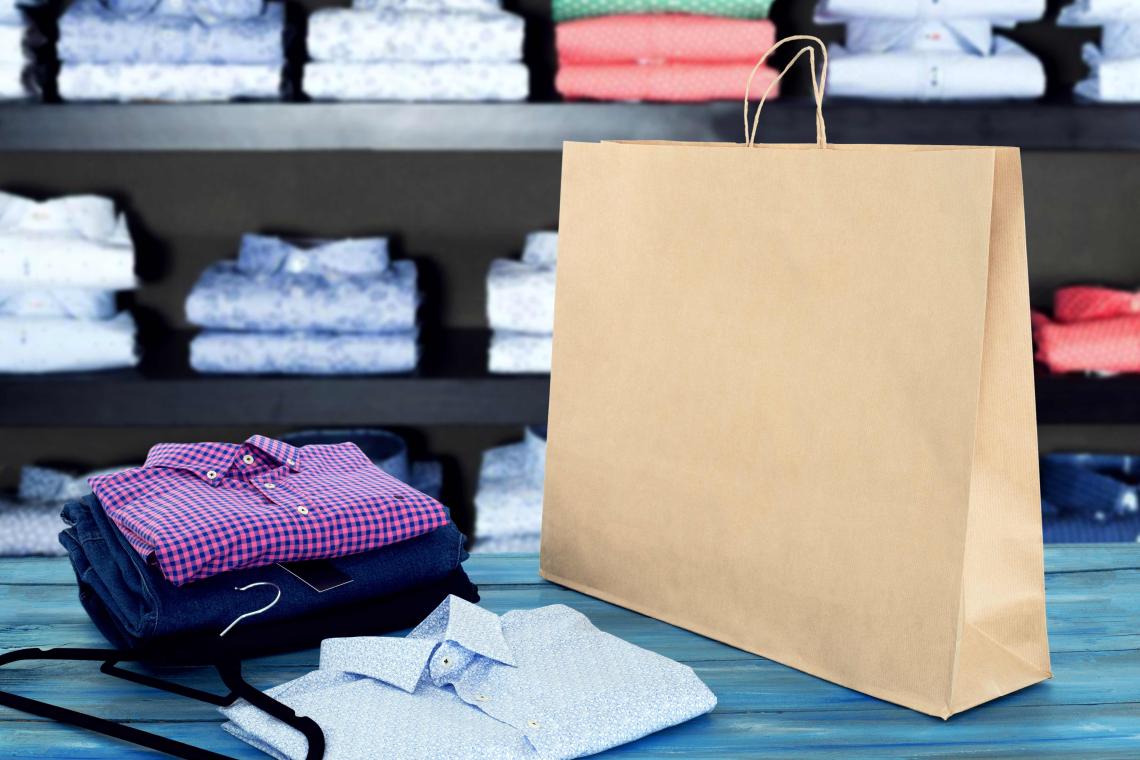 Bolsas de papel kraft grandes junto a unas camisas