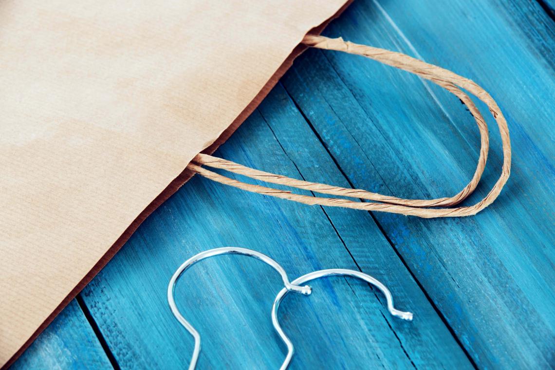 Bolsas de papel kraft grandes junto a unas camisas