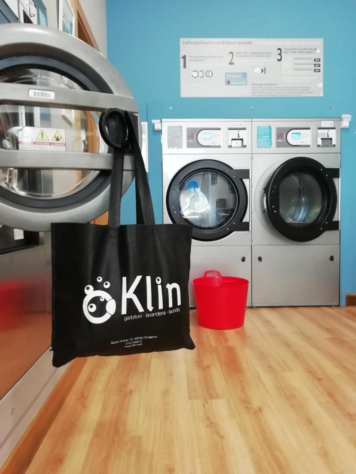 Bolsas de tela negras grandes con asas largas y fuelle en base en la lavandería