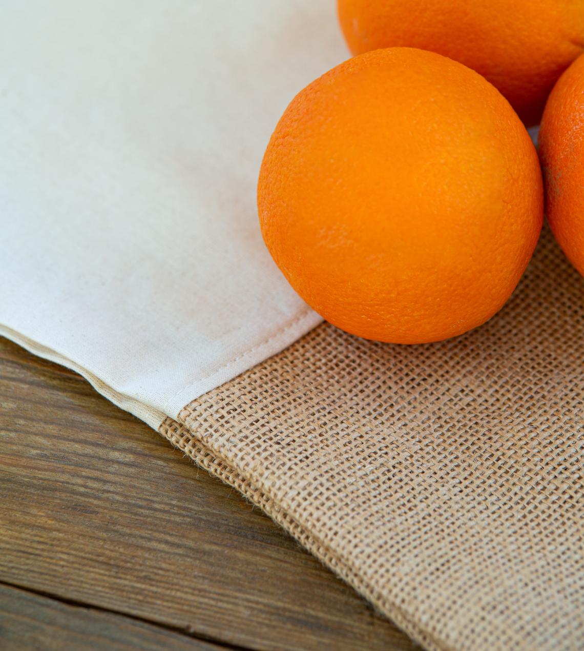 Bolsas de algodón orgánico y yute con  pan naranjas al lado