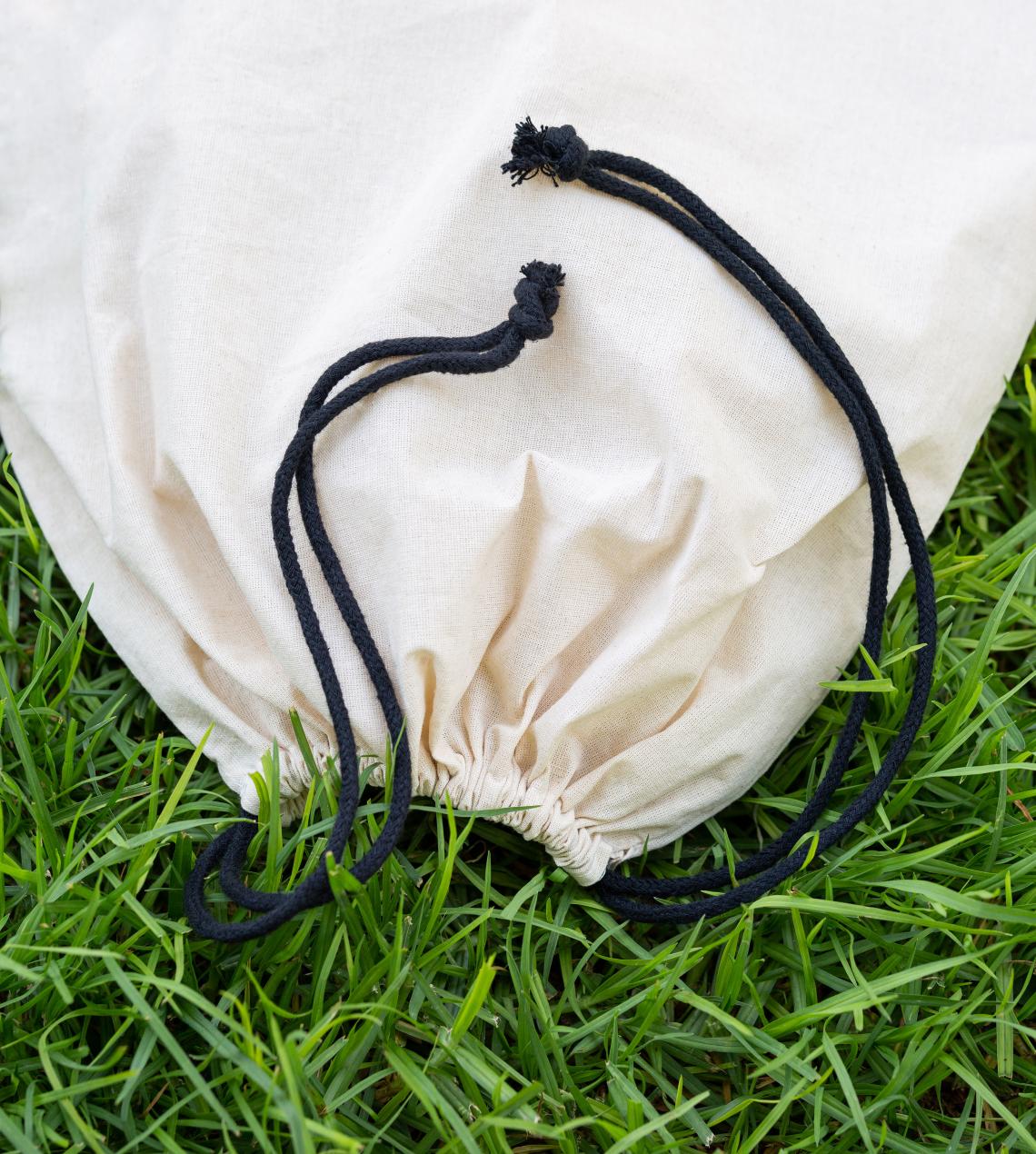 Sacos de algodón orgánico con cierres de cordones sobre césped