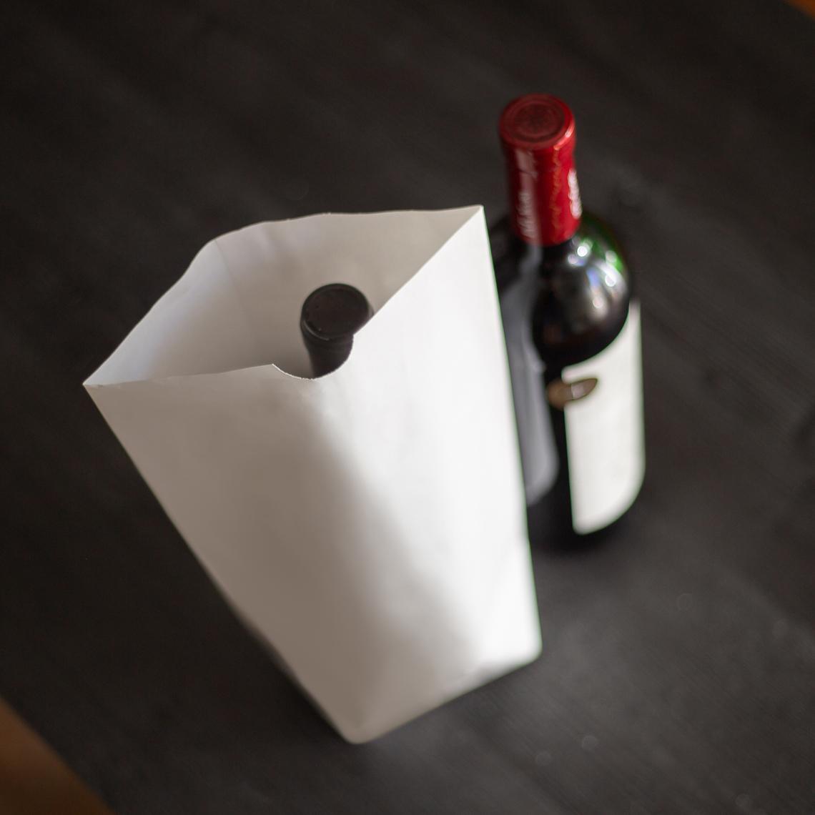 Bolsas de papel sin asas junto a una botella