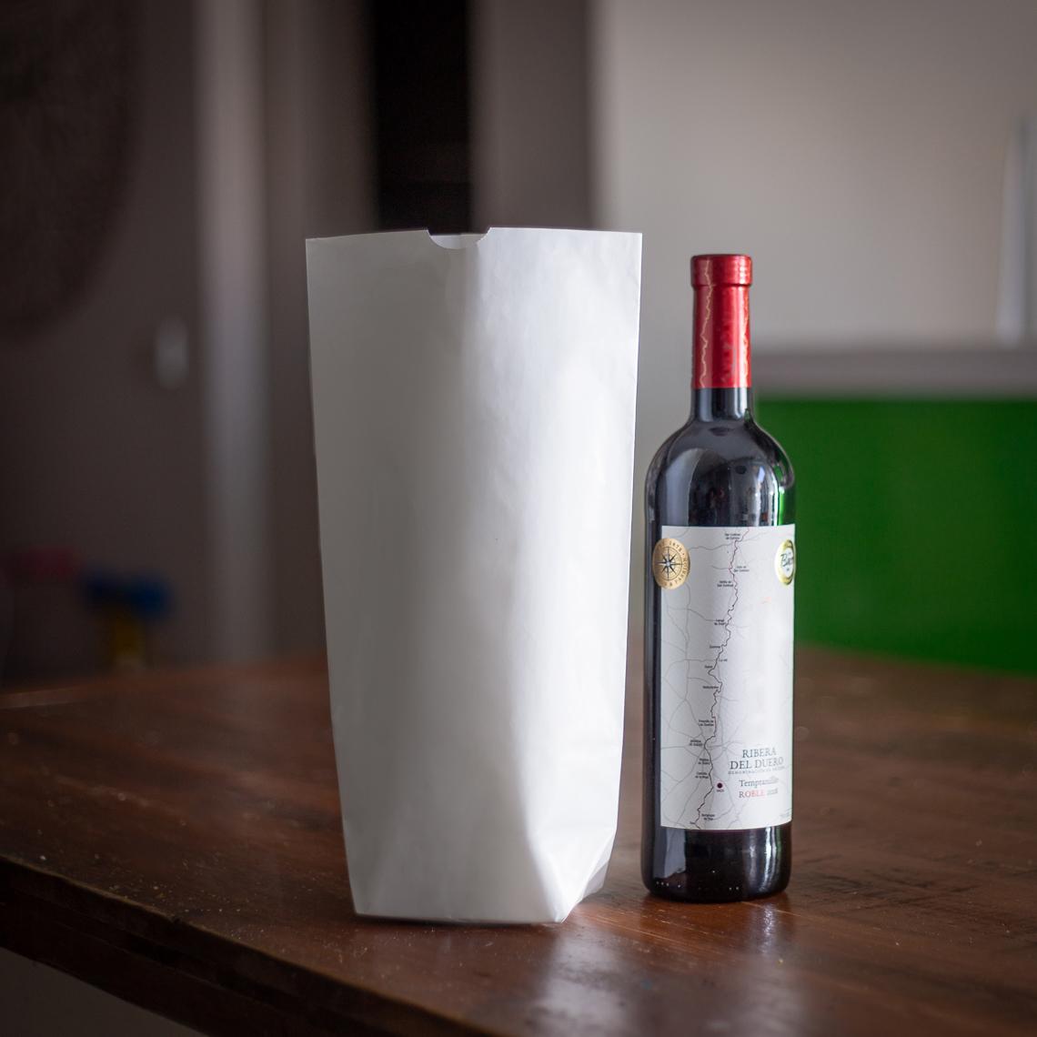 Bolsas de papel sin asas junto a una botella