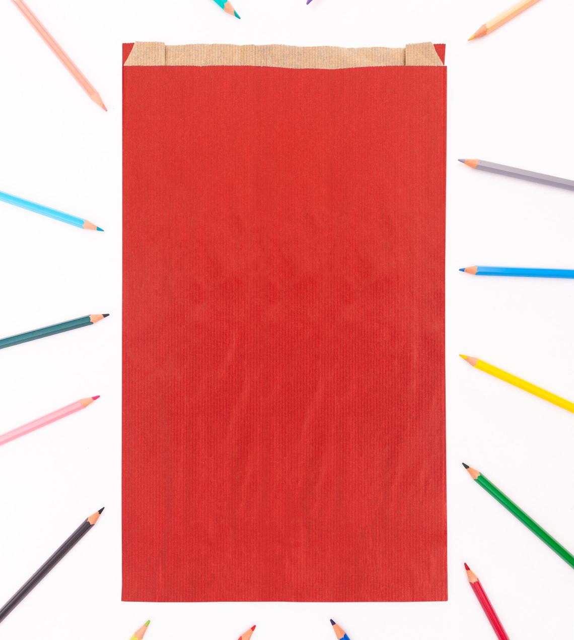 Sobres de papel rojos con lápices de colores alrededor