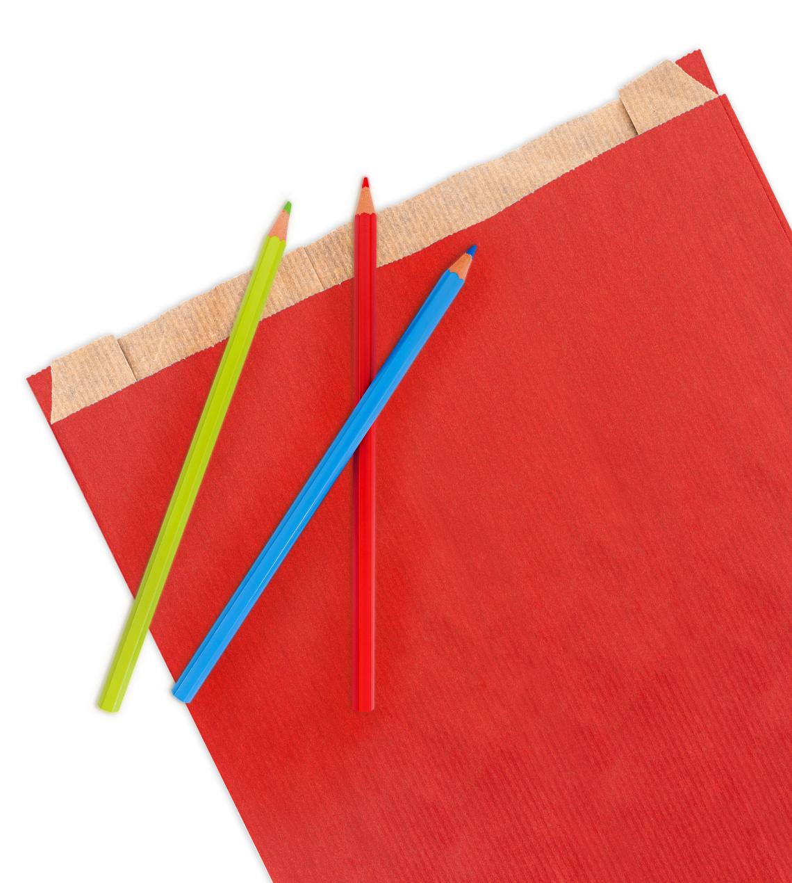 Sobres de papel rojos con lápices de colores alrededor