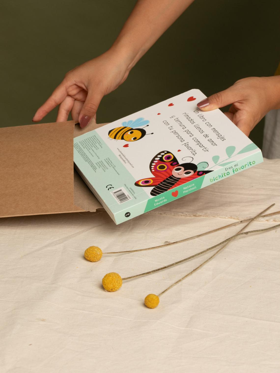 Sobre kraft ecológico para envíos de libros | Embalaje sostenible Bolsalea Manos introduciendo un libro infantil en un sobre kraft reciclable de Bolsalea. Fabricado en España con materiales sostenibles y empleo inclusivo.